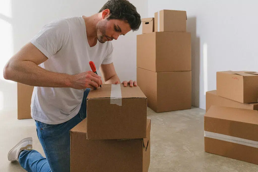 Man writing labels on boxes