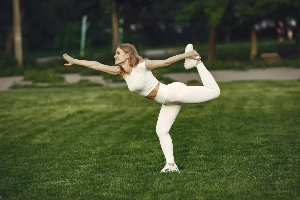 A woman doing yoga at the park